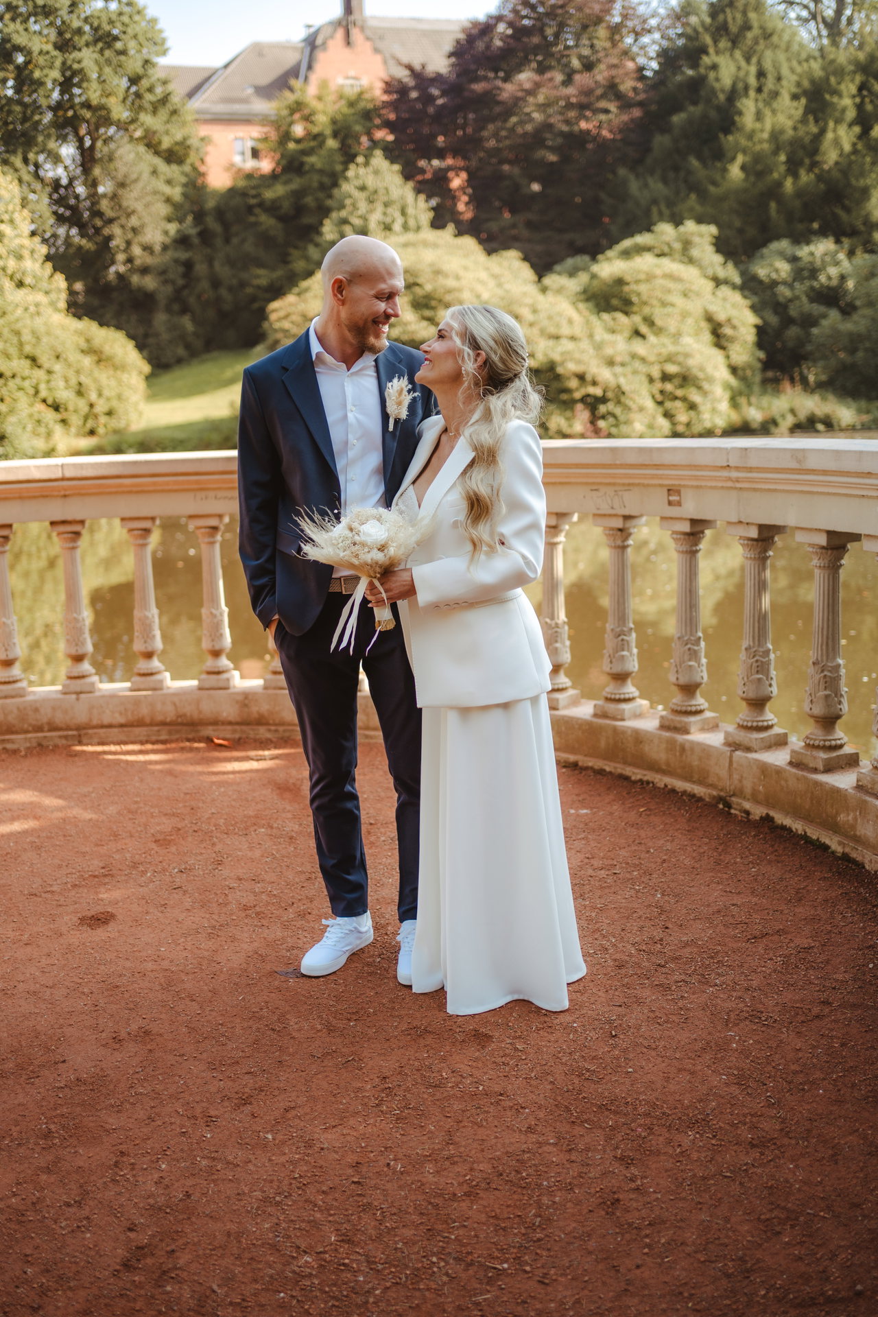 Elain und Marcel lachen sich vor einer Steinbalustrade an