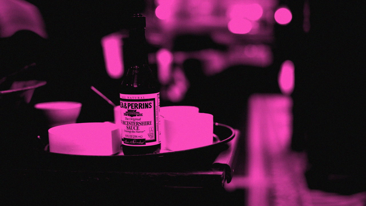 Eine Bierflasche steht auf einem Teller auf einem Tresen, Schwarzweiß mit Magenta-Duplex