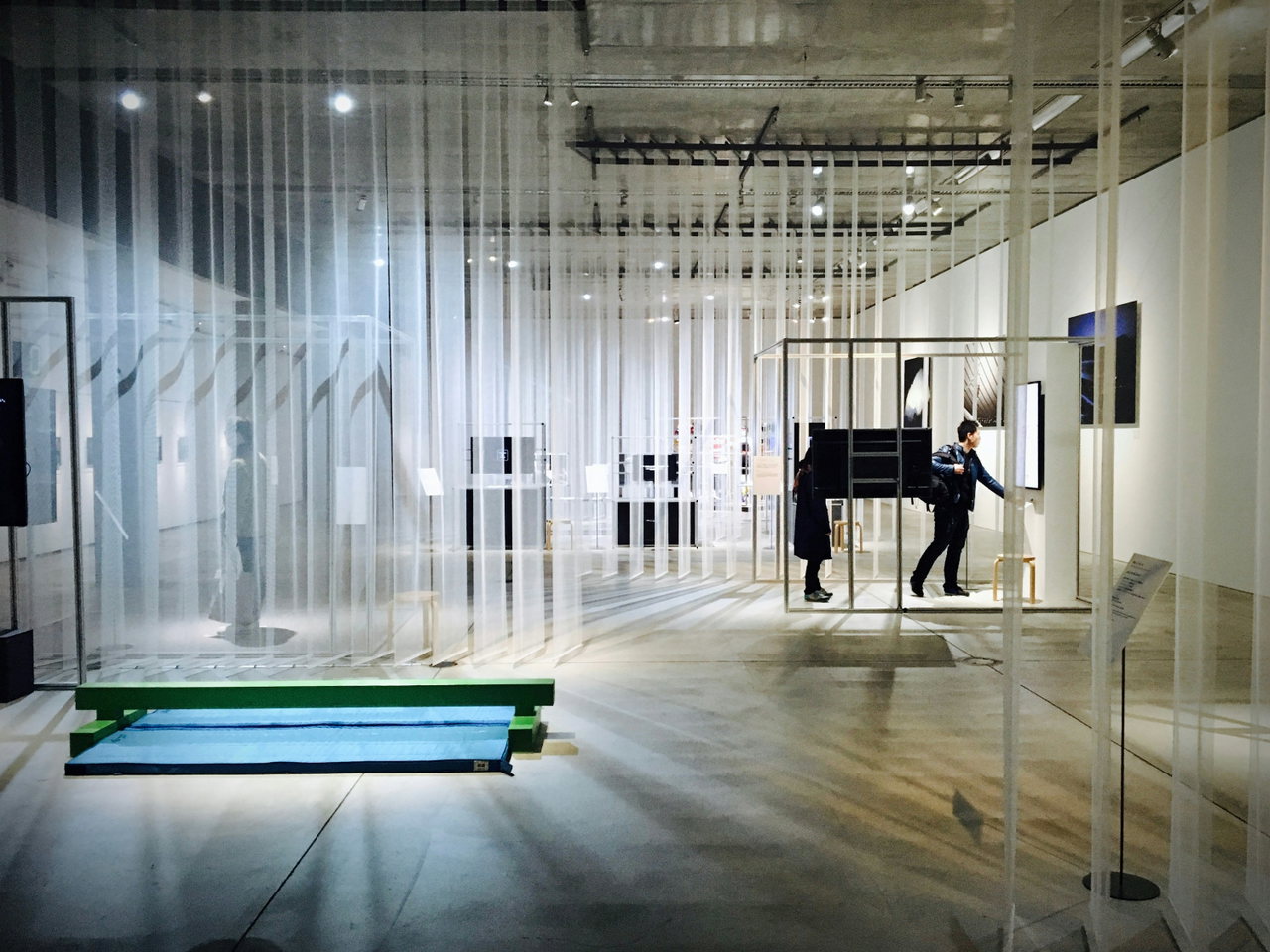 Heller, transparenter Ausstellungsraum mit Vorhängen aus Licht und einer Person im Hintergrund