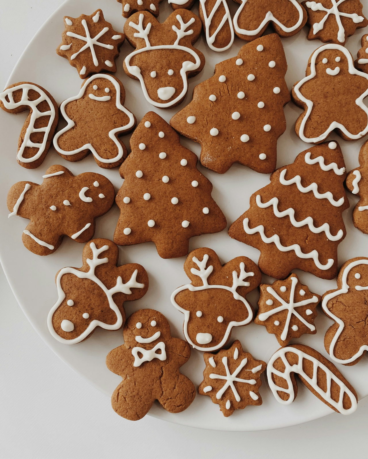 Verzierte Lebkuchen in Stern-, Herz- und Tannenform auf einem Teller