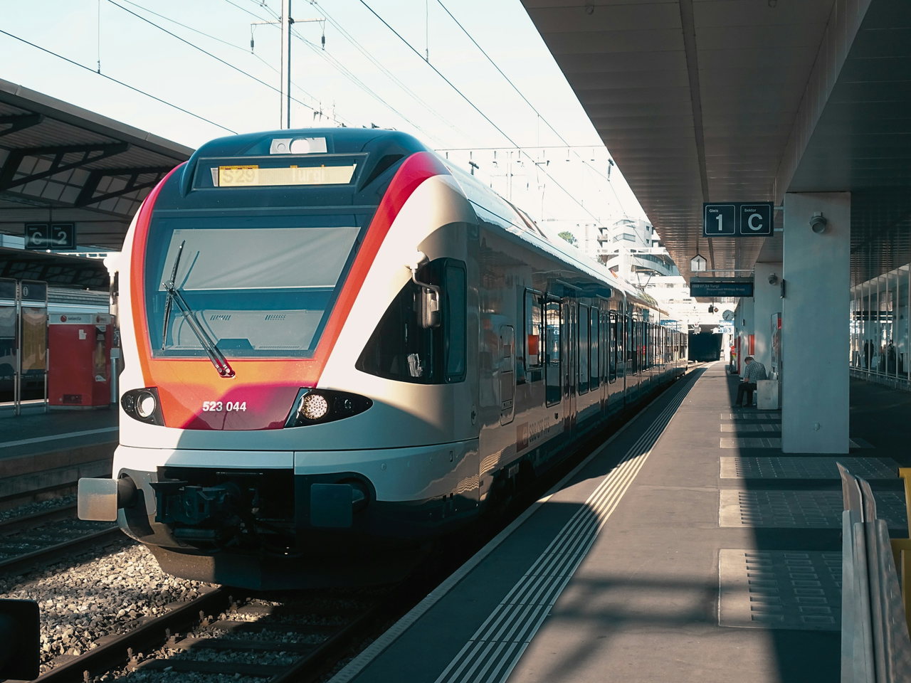 Modern regional train pulling into a station and standing at the platform under the roof
