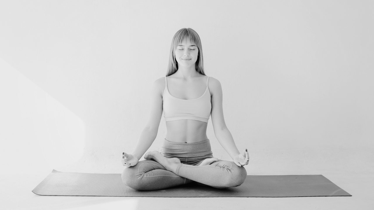 Auf diesem Bild wird die Yoga-Pose "einfacher Sitz" praktiziert. Sie dient als Schlußentspannung.