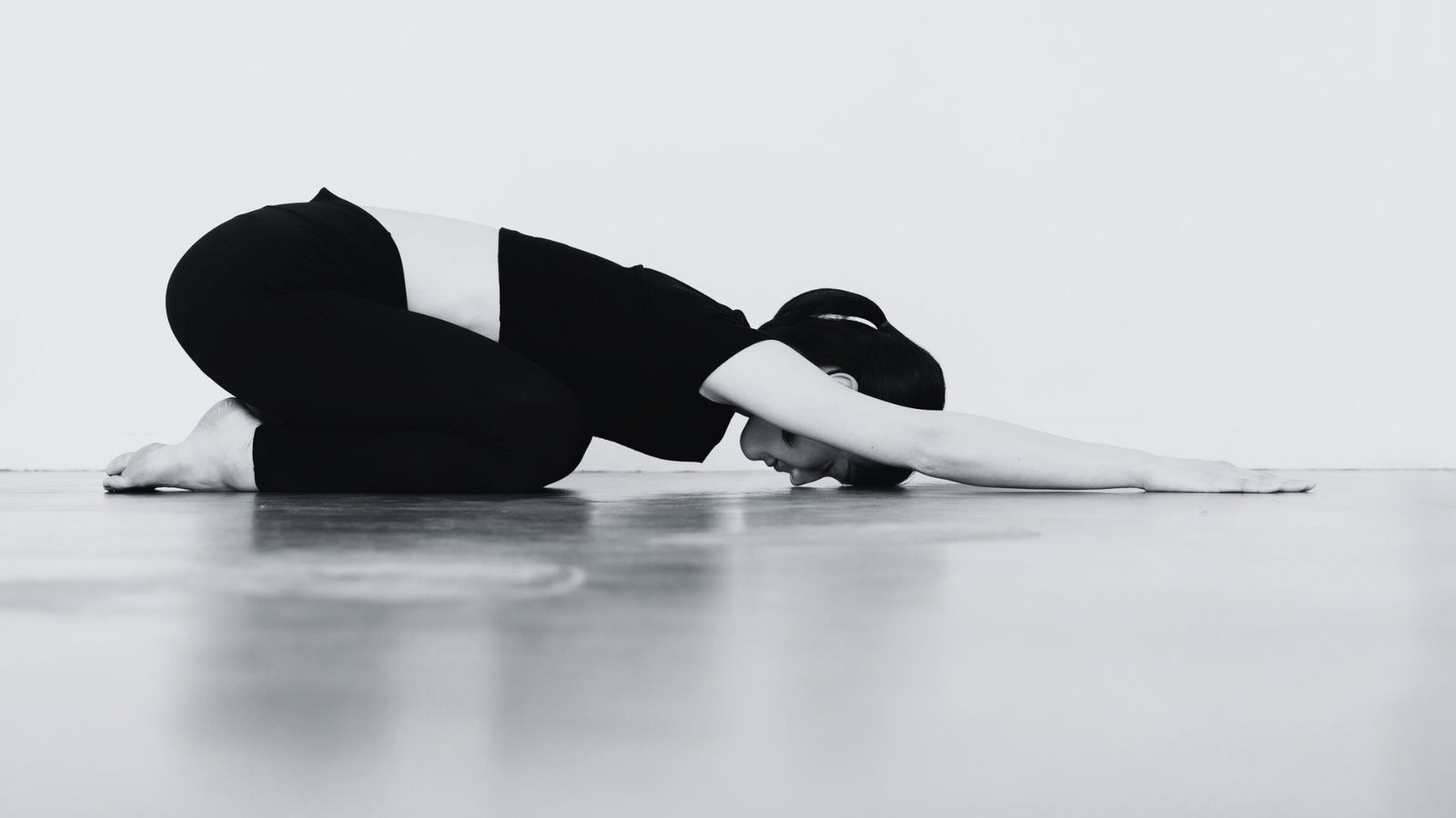 Dieses Bild zeigt eine Frau auf einer Yoga-Matte in der Stellung des Kindes.